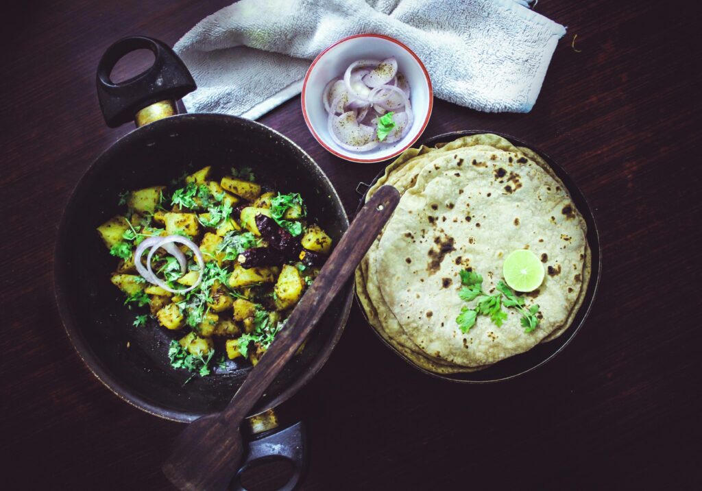 Bangalore-style home-cooked meal featuring roti, aloo fry, and fresh onions.